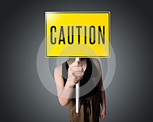 Young woman holding a caution sign