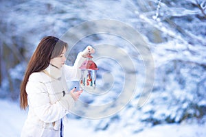 Young woman holding Christmas lantern outdoors on beautiful winter snow day