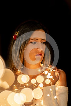 Young woman holding Christmas's string lights