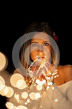 Young woman holding Christmas's string lights