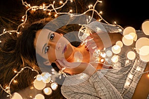 Young woman holding Christmas's string lights