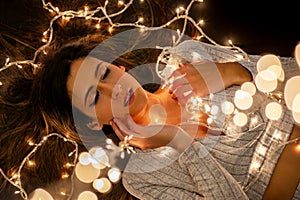 Young woman holding Christmas's string lights