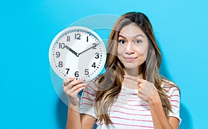 Young woman holding a clock