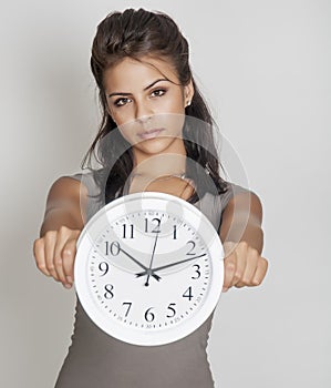 Young woman holding clock