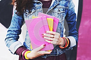 Young woman holding colorful copybooks in her hands