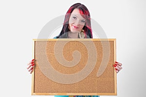 Young woman holding a cork board.