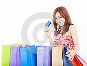 Young woman holding credit card with shopping bags