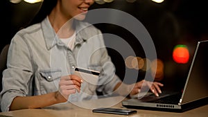 Young woman holding credit card shopping on laptop, online deposit, transaction