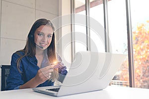 Young woman holding credit card and using a laptop computer.