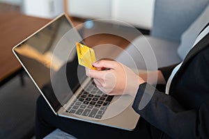 Young woman holding credit card using for online shopping