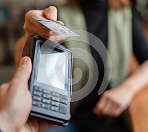 Young woman holding credit doing wireless bank payment with POS terminal process acquire at table in coffee shop cafe restaurant