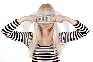 Young woman holding dollar over her eyes