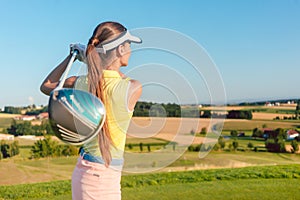 Young woman holding a driver club during golf swing at the begin