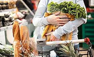 Young woman holding eco bag with greenery.