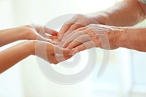 Young woman holding elderly man hands