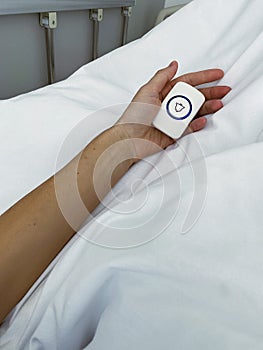 Young woman holding emergency nurse call button in hospital room