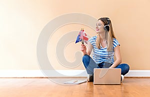 Young woman holding English speaking country flags with laptop