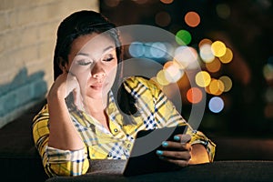 Young Woman Holding Ereader And Reading Ebook At Night