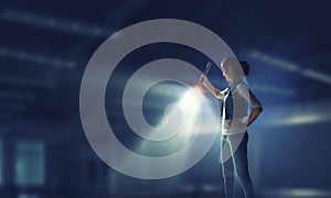 Young woman holding a flashlight