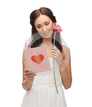 Young woman holding flower and postcard