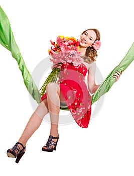 Young woman holding flowers on swing.