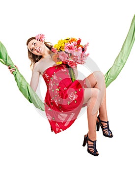 Young woman holding flowers on swing.