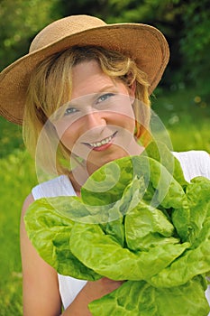 Young woman holding fresh lettuce