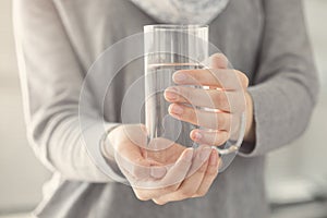 Young woman holding glass of water