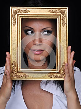 Young woman holding gold antique frame