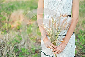 Young woman holding grass flowers.