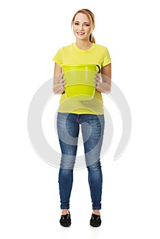 Young woman holding green bucket.