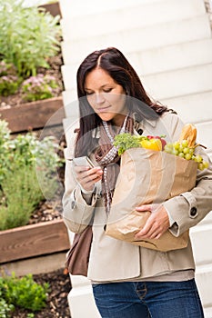 Young woman holding groceries vegetables shopping phone