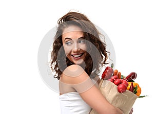 Young woman holding grocery paper shopping bag full of fresh vegetables. Diet healthy eating concept