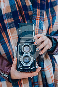 Young woman holding in hands old vintage camera. Girl photographer