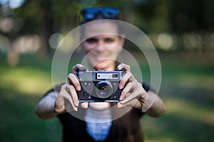 Young woman holding in hands old vintage camera