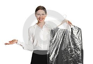 Young woman holding hanger with dress in plastic bag on background. Dry-cleaning service