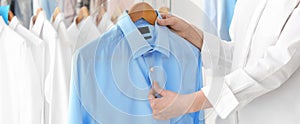 Young woman holding hanger with shirt, banner design. Dry-cleaning service