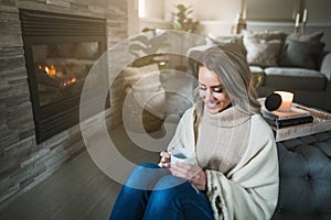 Young woman holding her coffee mug in cozy living room
