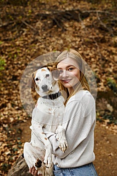 Young woman holding her dog in