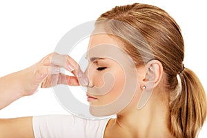 Young woman holding her nose because of a bad smell