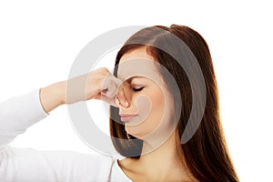 Young woman holding her nose because of a bad smell