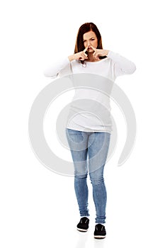 Young woman holding her nose because of a bad smell