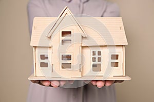 Young woman holding house model