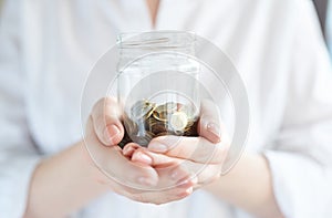 Young woman holding a jar of money. economic crisis. Save Money