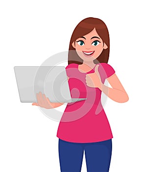 Young woman holding laptop computer and thumbs up gesture. Trendy girl using gadget and showing good or like sign.
