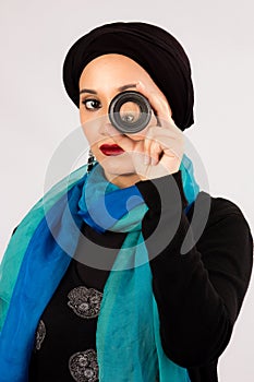 Young Woman holding a lens in hijab and colorful scarf