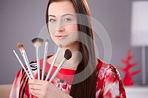 Young woman holding make-up brushes