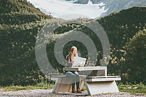 Young Woman holding map planning journey route in Norway sitting at the table Travel Lifestyle concept adventure vacations