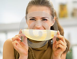 Young woman holding melon slice in front of mouth