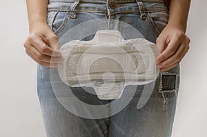 Young woman holding menstrual pad ,Women Period Product. Closeup asian female holding Sanitary Napkin, In Hand. Woman Holding